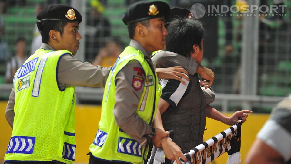 Seorang fans diamankan polisi setelah mencoba memasuki lapangan setelah pertandingan antara ISL Stars vs Juventus usai.